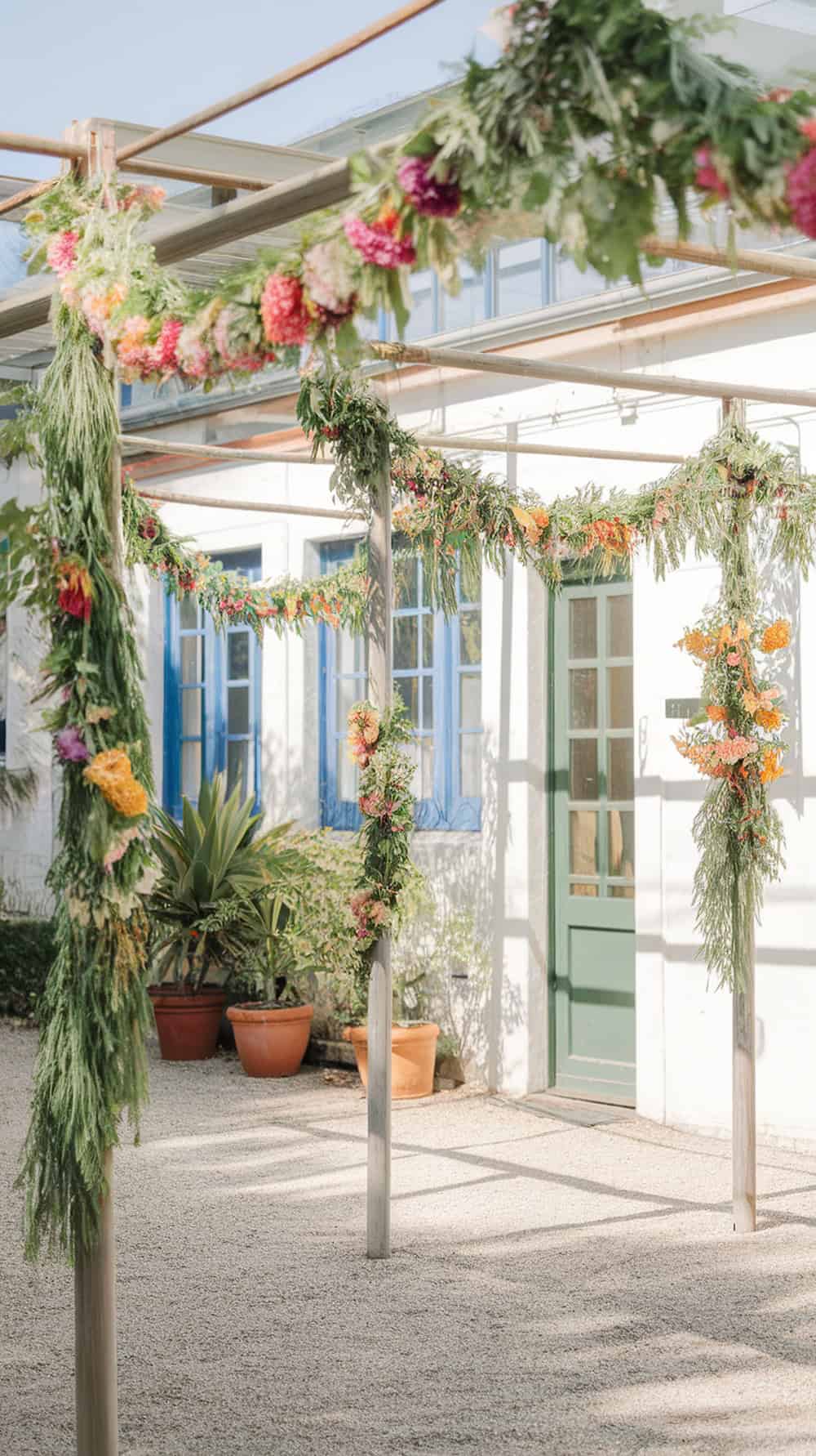 Flower garlands wrapped around poles at a garden party