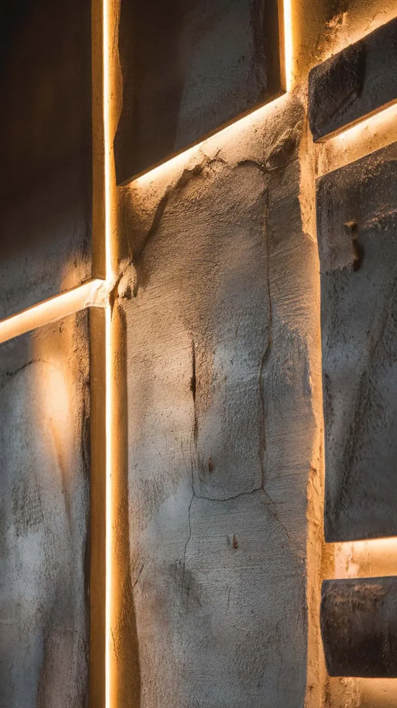 Close-up of a textured concrete wall with warm lighting