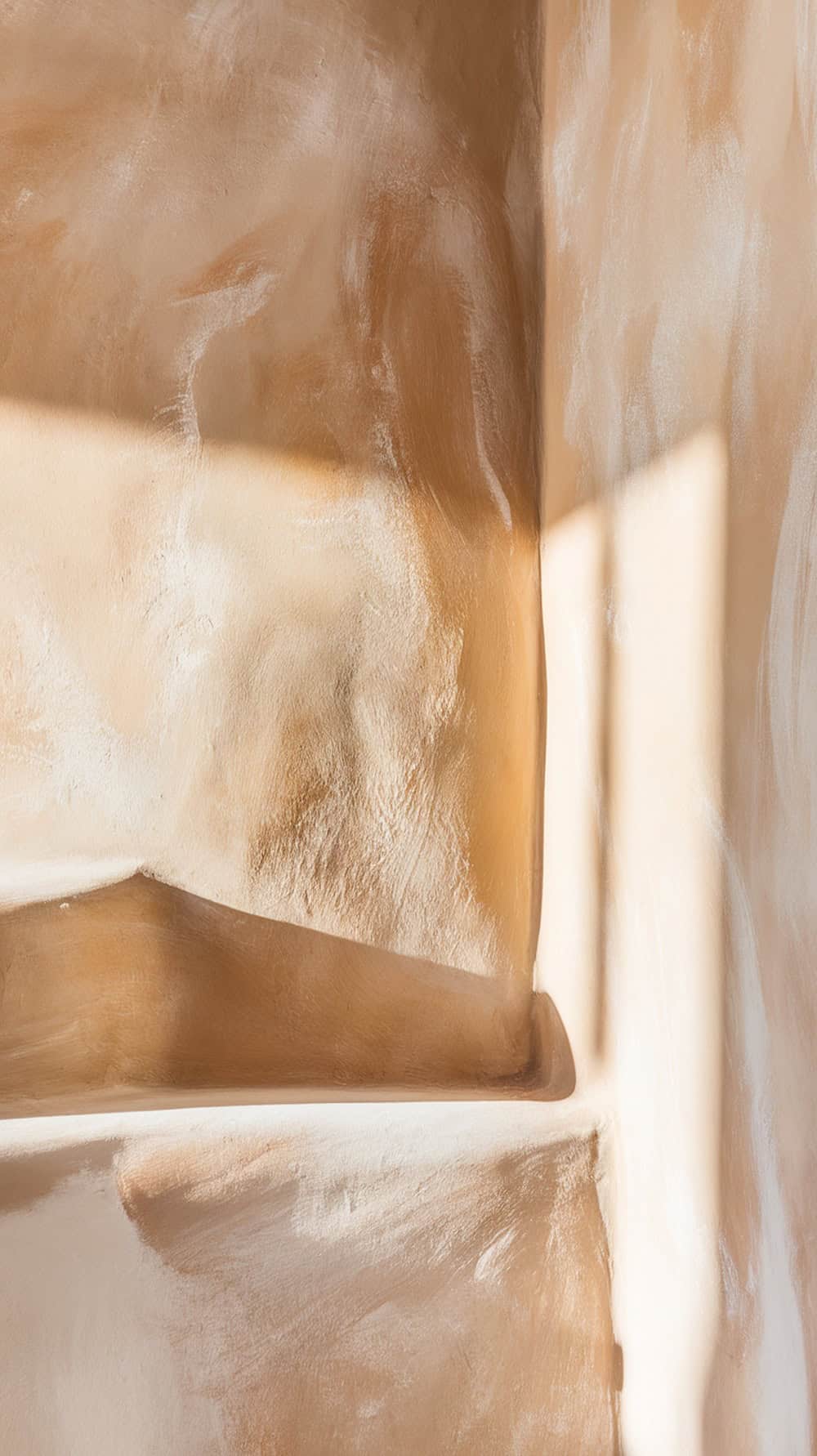 A close-up of a rustic stucco wall with soft color variations.