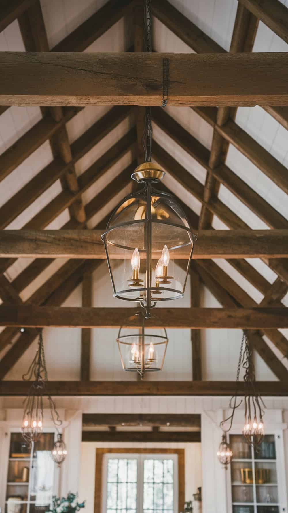 Wrought iron and brass light fixtures hanging from a wooden ceiling in a cozy farmhouse interior.